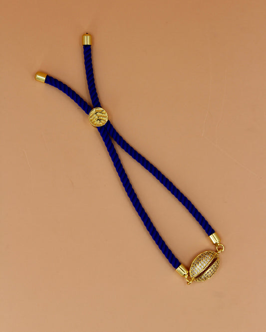 Adjustable cord bracelet with gold cowrie charm, handmade coastal jewelry by Cuya, available in multiple colors.