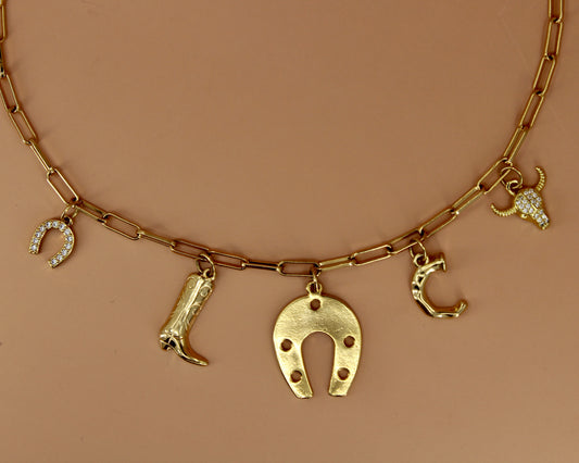 18k gold plated Western charm necklace with customizable initial, horseshoe, cowboy boot, bull skull, and paperclip chain, bold cowgirl jewelry by Cuya.