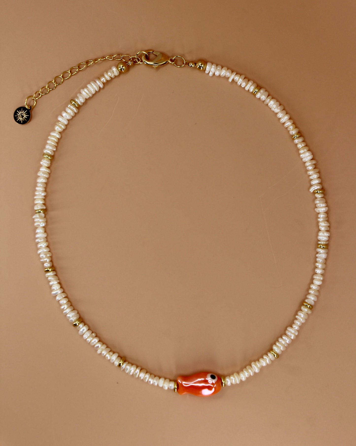Handmade freshwater pearl necklace with gold accents and colorful glass fish charm, ocean-inspired coastal jewelry by Cuya.