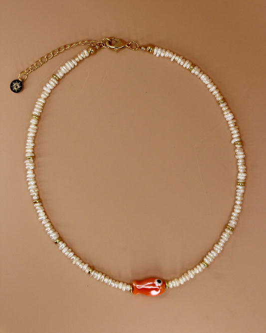 Handmade freshwater pearl necklace with gold accents and colorful glass fish charm, ocean-inspired coastal jewelry by Cuya.
