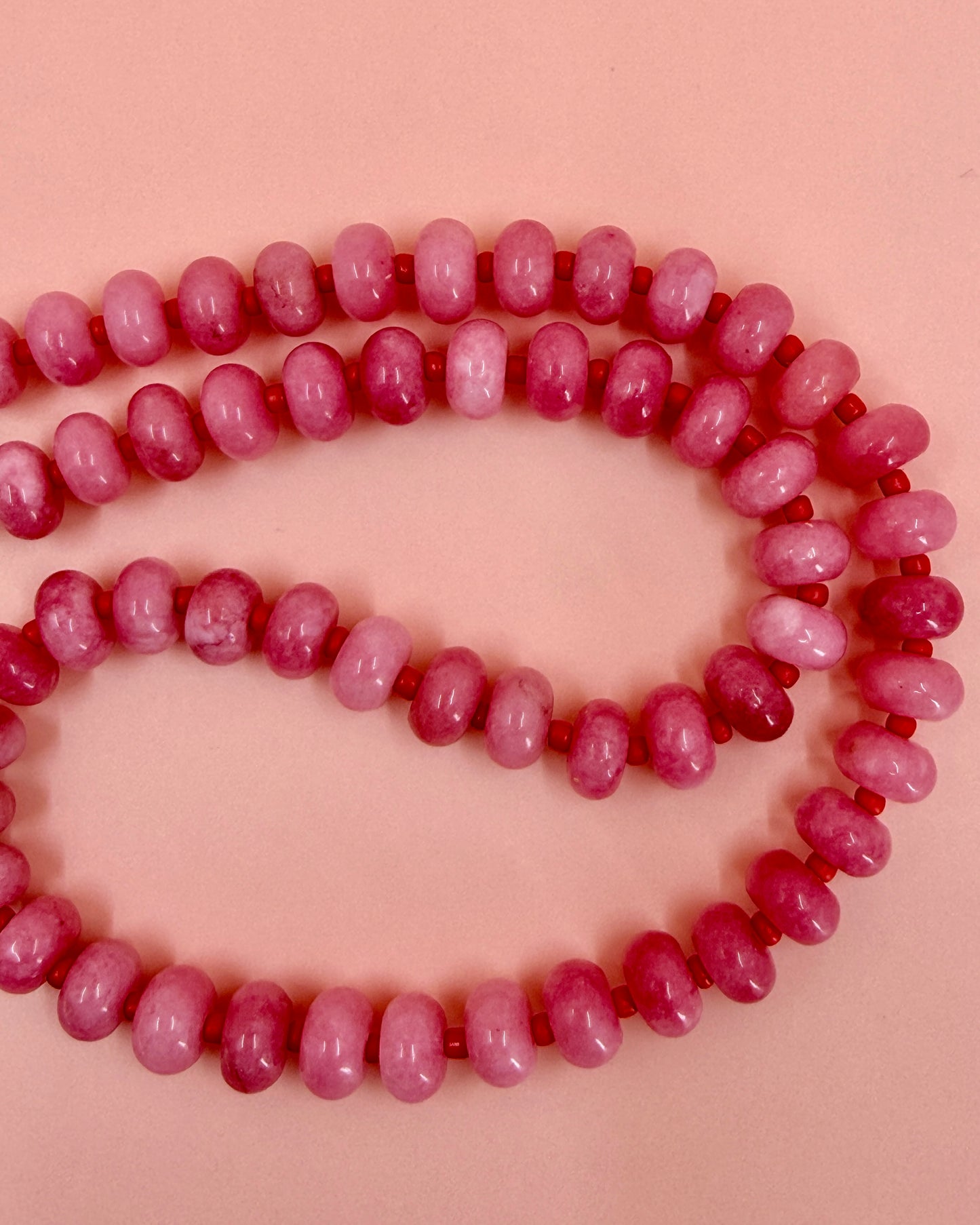 Handmade beaded necklaces in pink with gold sailor clasps for interchangeable charms, customizable coastal jewelry by Cuya.