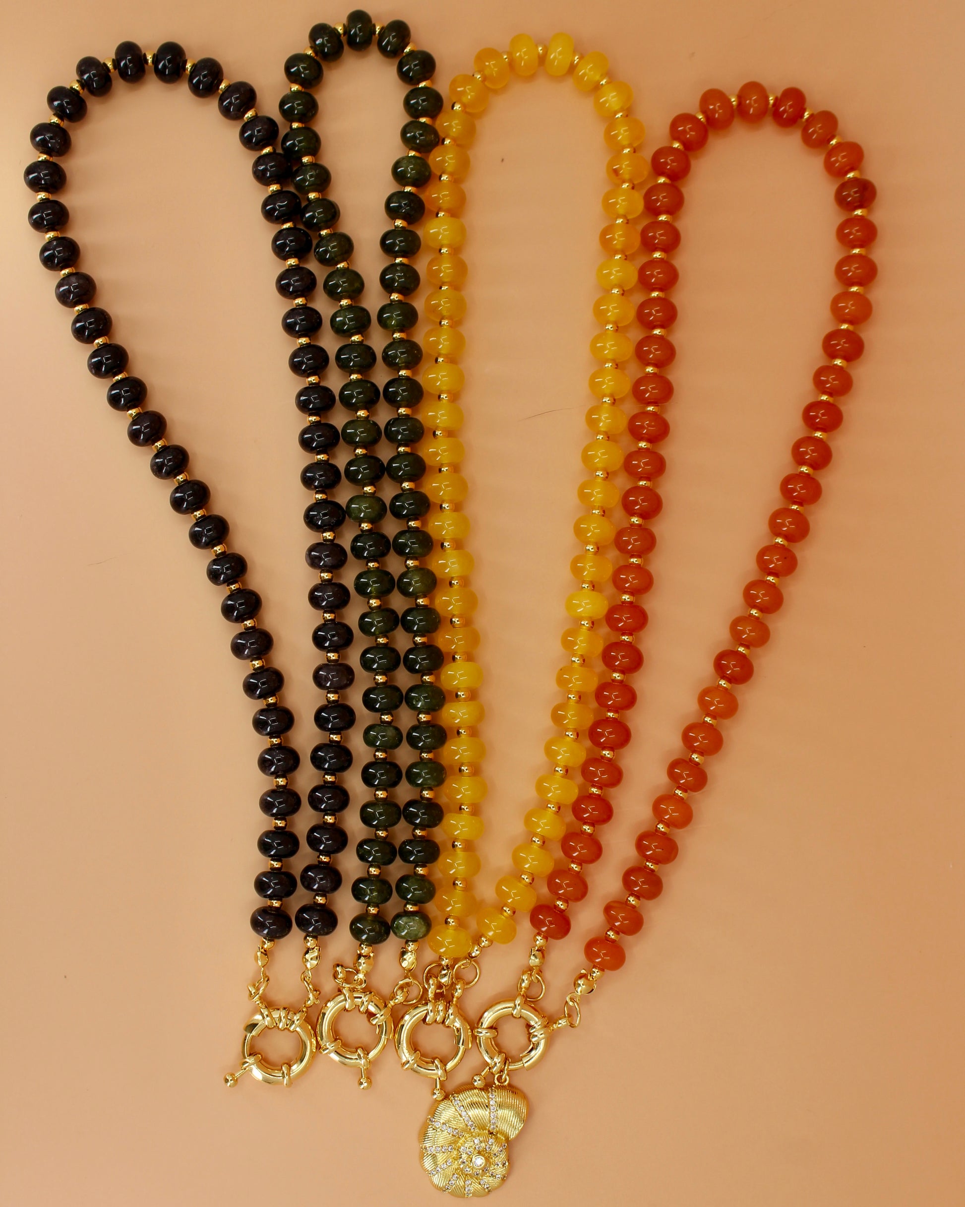 Handmade beaded necklaces in navy blue, green, yellow and orange with gold sailor clasps for interchangeable charms, customizable coastal jewelry by Cuya.