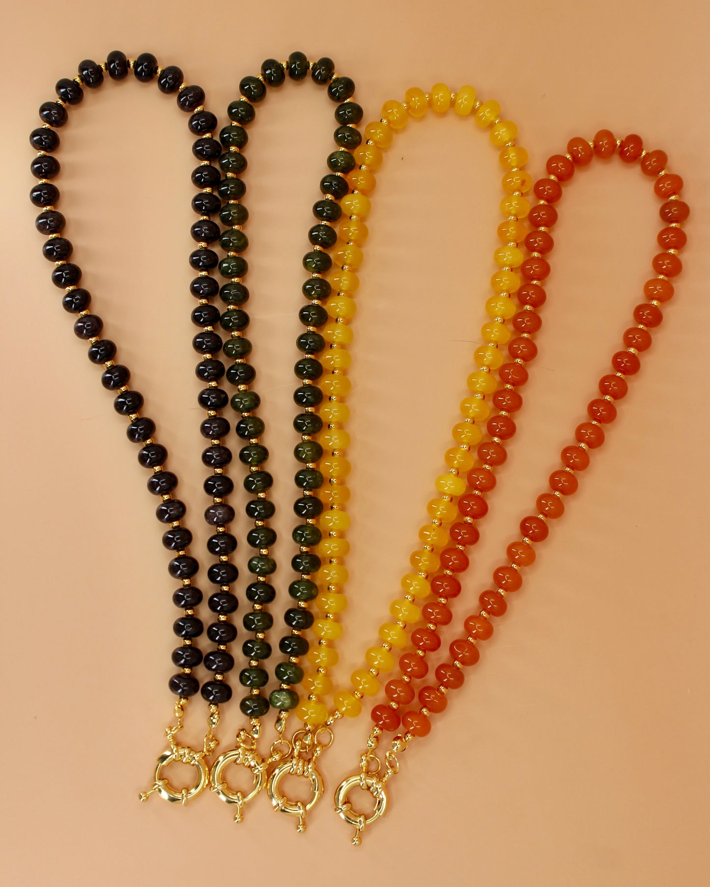 Handmade beaded necklaces in navy blue, green, yellow and orange with gold sailor clasps for interchangeable charms, customizable coastal jewelry by Cuya.