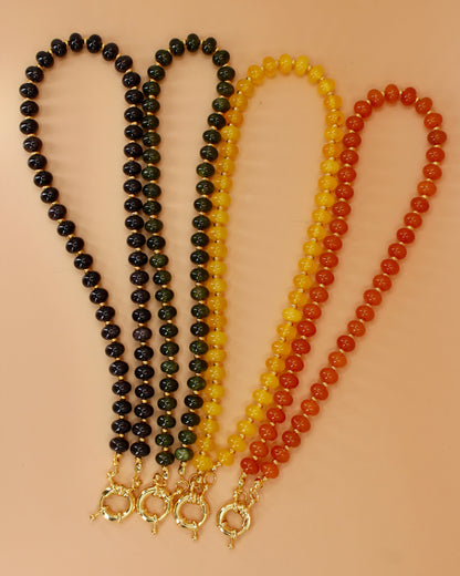 Handmade beaded necklaces in navy blue, green, yellow and orange with gold sailor clasps for interchangeable charms, customizable coastal jewelry by Cuya.