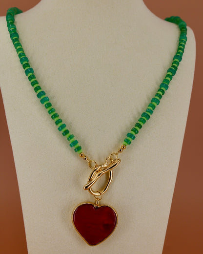 Handmade green beaded necklace with red heart pendant and gold toggle clasp, colorful coastal statement jewelry by Cuya.