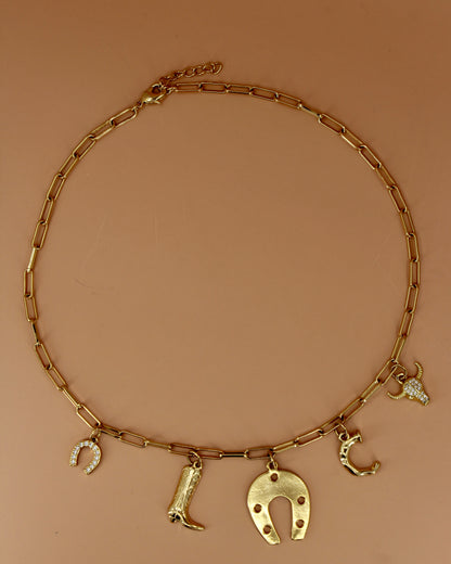 18k gold plated Western charm necklace with customizable initial, horseshoe, cowboy boot, bull skull, and paperclip chain, bold cowgirl jewelry by Cuya.