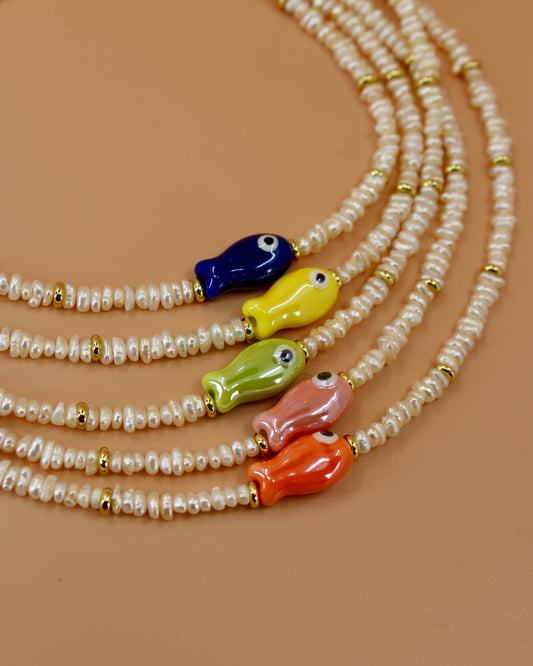 Handmade freshwater pearl necklace with gold accents and colorful glass fish charm, ocean-inspired coastal jewelry by Cuya.