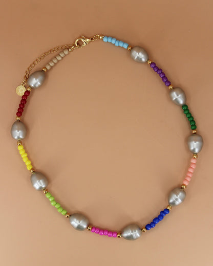 Handmade colorful glass bead necklace with imitation mother of pearls and gold accents, bold statement jewelry by Cuya.Handmade colorful glass bead necklace with imitation mother of pearls and gold accents, bold statement jewelry by Cuya.