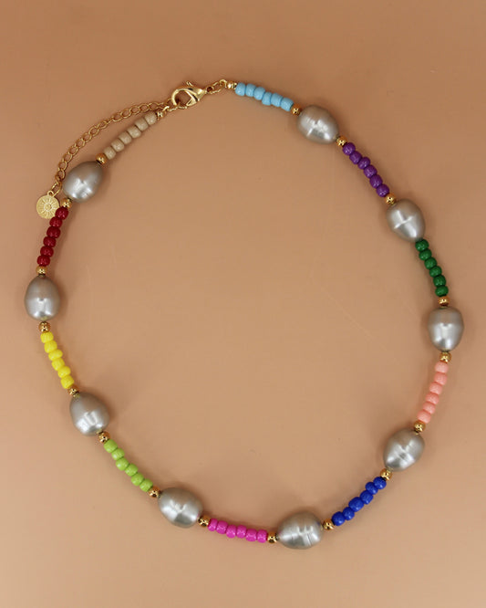 Handmade colorful glass bead necklace with imitation mother of pearls and gold accents, bold statement jewelry by Cuya.Handmade colorful glass bead necklace with imitation mother of pearls and gold accents, bold statement jewelry by Cuya.