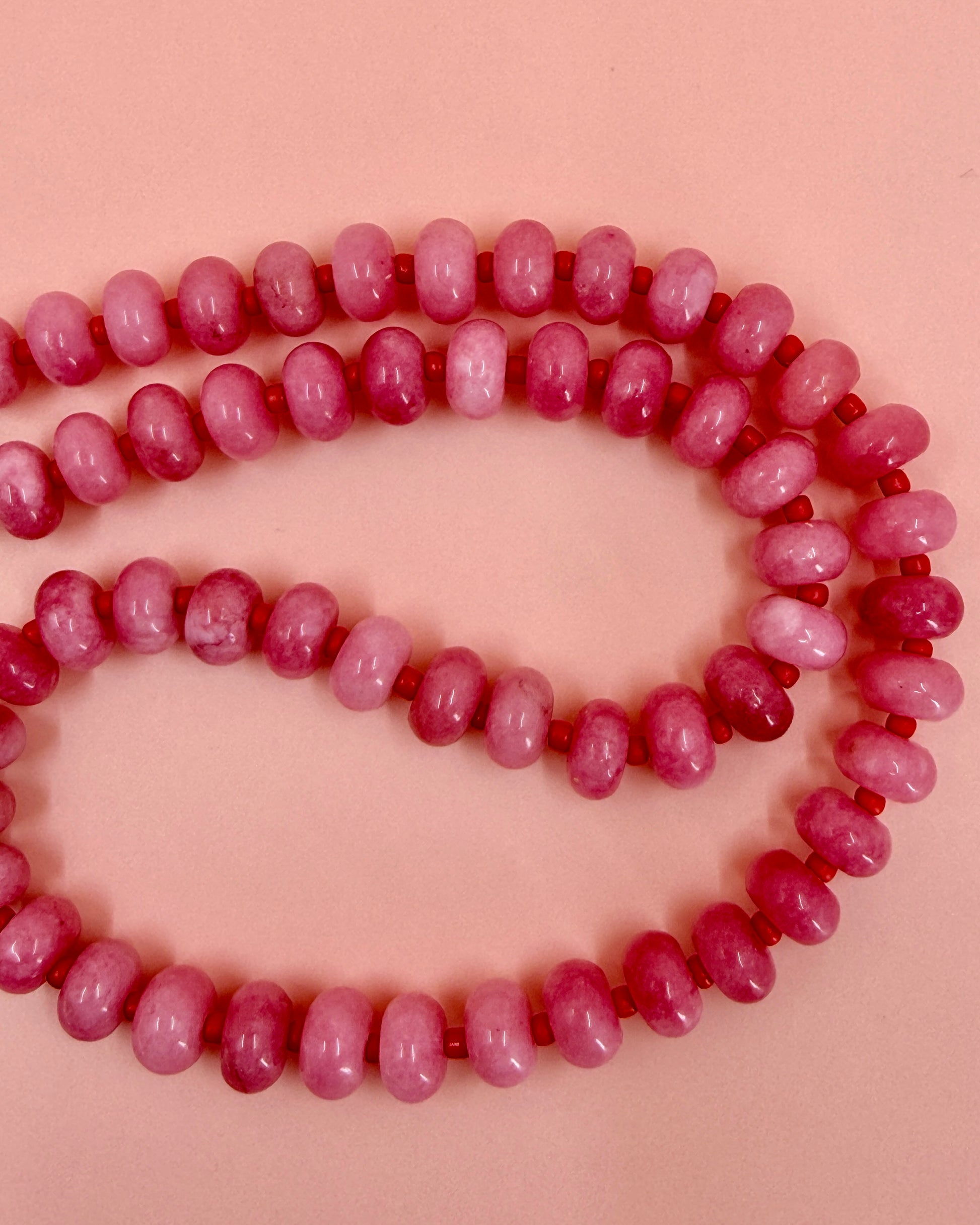 Handmade beaded necklaces in pink with gold sailor clasps for interchangeable charms, customizable coastal jewelry by Cuya.