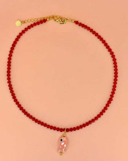 Handcrafted red gemstone necklace with a pink ceramic fish pendant. The Riva Necklace is available in 16”, 18”, and 20” lengths.