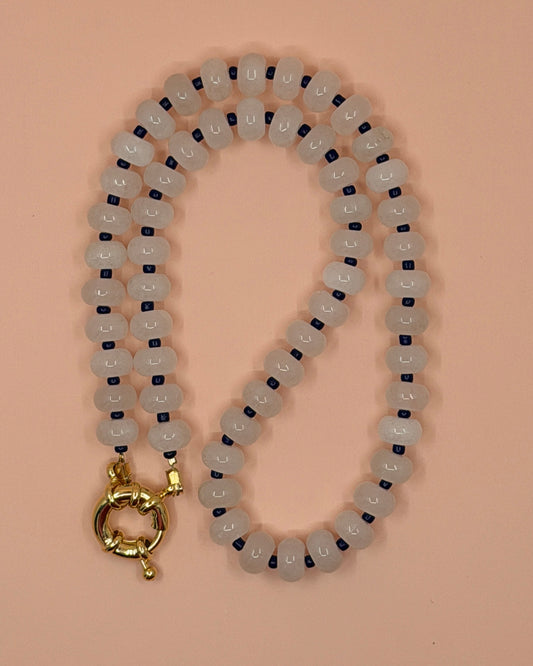 Beaded necklace with a gold clasp on a beige background