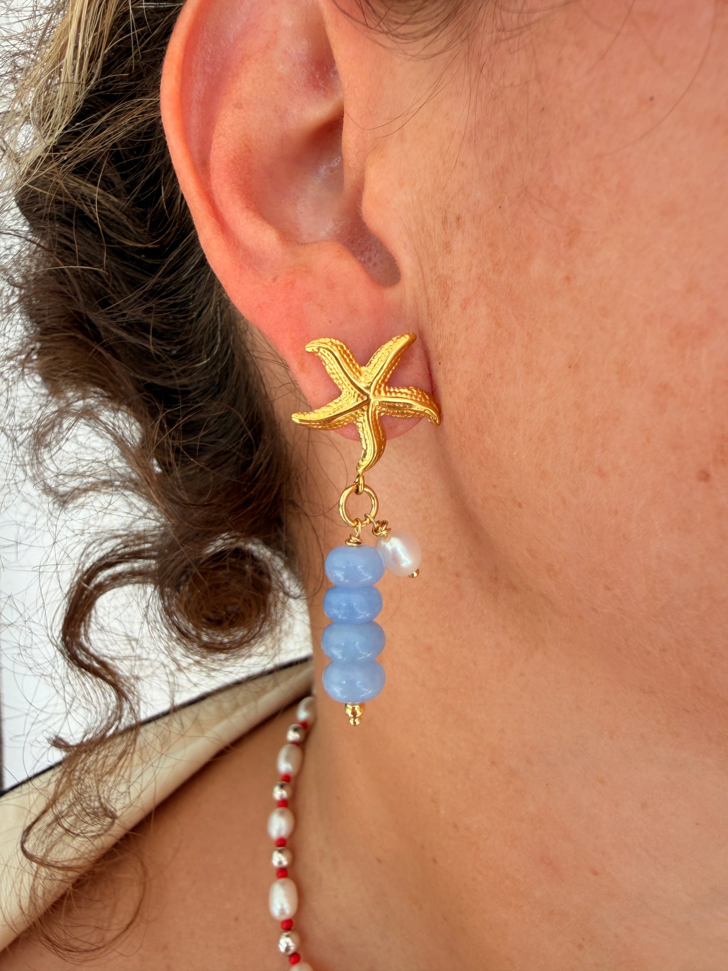 Limited-edition starfish earrings featuring gold-plated stainless steel, jade beads, and freshwater pearls. Handmade in small batches by Cuya Jewelry.