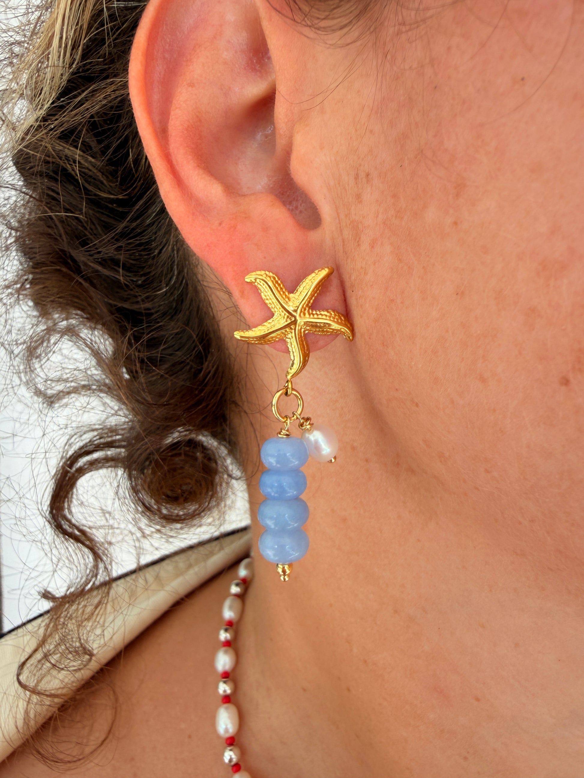 Limited-edition starfish earrings featuring gold-plated stainless steel, jade beads, and freshwater pearls. Handmade in small batches by Cuya Jewelry.