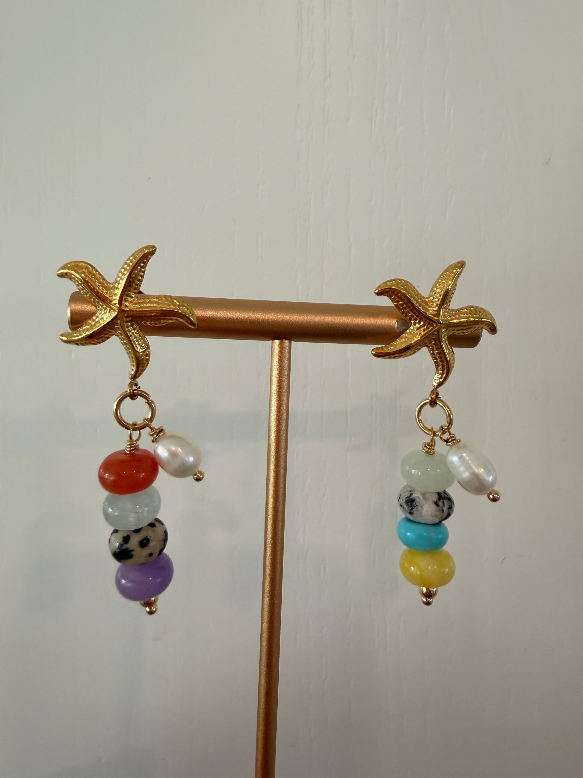 Limited-edition starfish earrings featuring gold-plated stainless steel, jade beads, and freshwater pearls. Handmade in small batches by Cuya Jewelry.