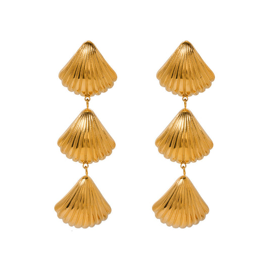 Gold shell-shaped earrings on a seashell beachy summer beach ocean sea hippie boho chic travel trendy stylish style